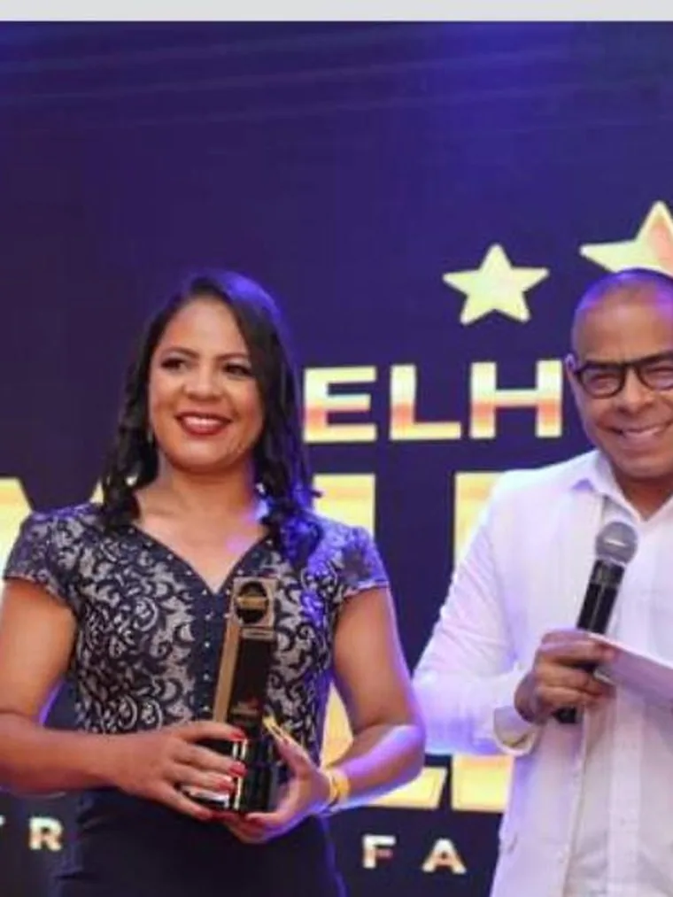 Marileide Oliveira recebendo o troféu Melhor dos Melhores das mãos do apresentador da cerimônia