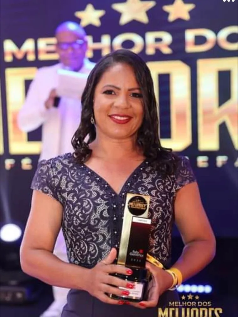Marileide Oliveira segurando o troféu Melhor dos Melhores 2023 no palco da premiação